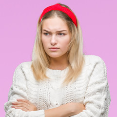 Young caucasian woman wearing winter sweater over isolated background skeptic and nervous,...