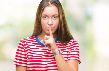 Fototapeta premium Young caucasian beautiful woman over isolated background asking to be quiet with finger on lips. Silence and secret concept.
