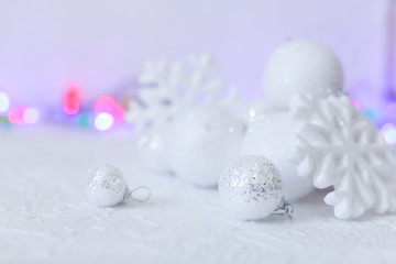 new year or Christmas decorations in silver and white colors with balls, snowflakes and garland bokeh