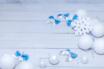 Christmas or new year composition in silver white and blue colors with balls snowflake and bows on white wood