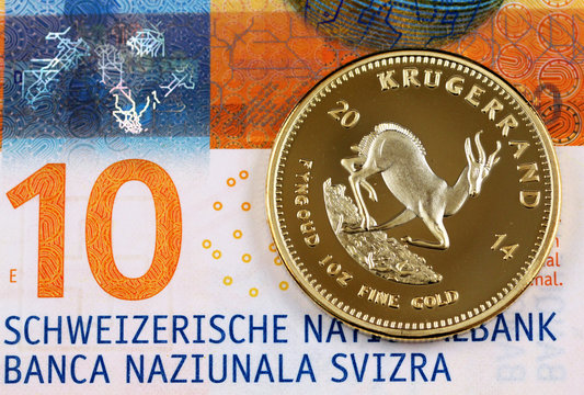 A macro image of a ten Swiss Franc bank note with a one ounce Krugerrand coin