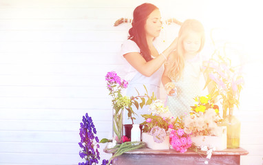 A young girl with a daughter is picking up a bouquet. A young mo