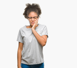 Fototapeta na wymiar Young afro american woman wearing glasses over isolated background touching mouth with hand with painful expression because of toothache or dental illness on teeth. Dentist concept.