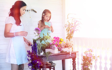 A young girl with a daughter is picking up a bouquet. A young mo