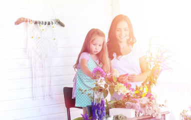 A young girl with a daughter is picking up a bouquet. A young mo