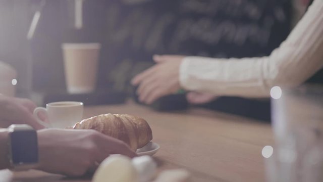 Buying a croissant and coffee at the bar in cafe,