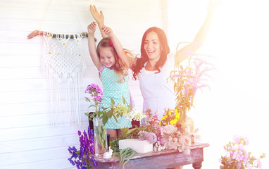 A young girl with a daughter is picking up a bouquet. A young mo