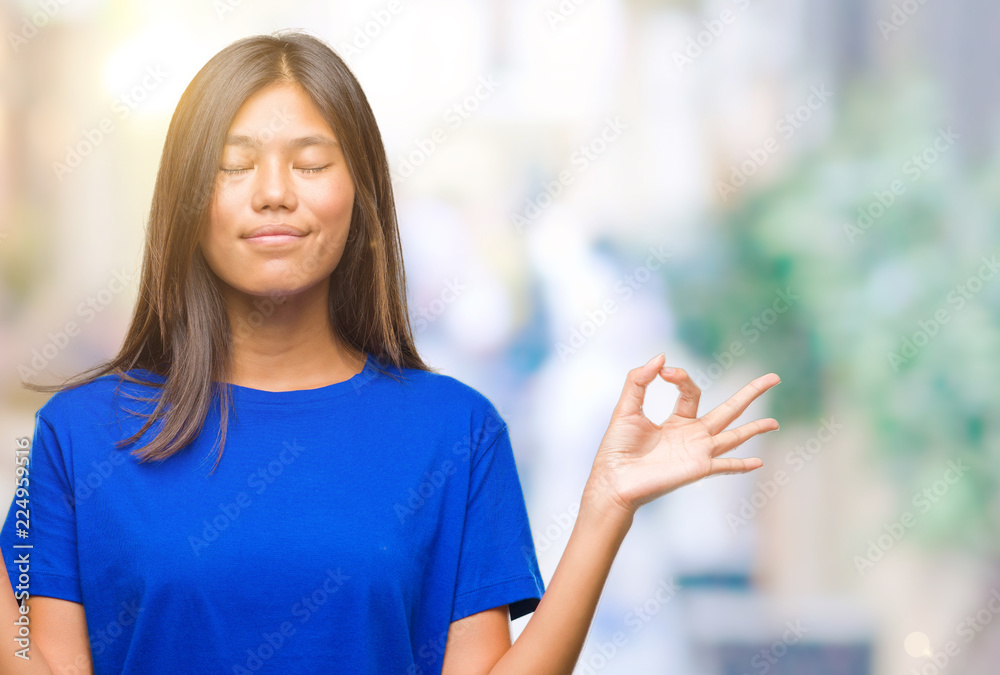 Wall mural young asian woman over isolated background relax and smiling with eyes closed doing meditation gestu