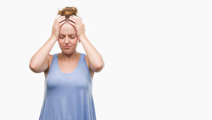 Young blonde woman suffering from headache desperate and stressed because pain and migraine. Hands on head.