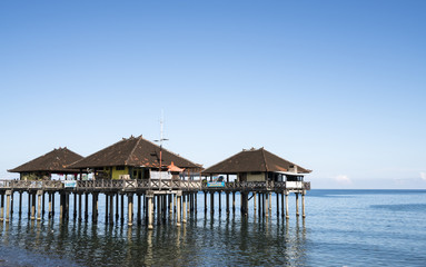 Traditional Balinese stilt houses in the sea at the old harbor, Singaraja, Bali, Indonesia