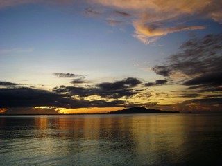 Gorgeous clouds cast golden reflections on the sea at sunset