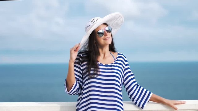 Pretty woman in sunglasses smiling having good time outdoor standing near antique railing