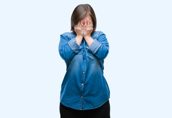 Young adult woman with down syndrome over isolated background with sad expression covering face...