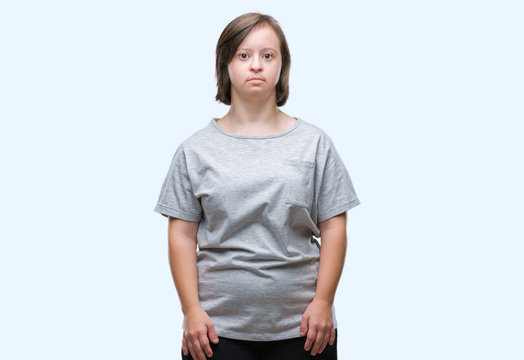 Young adult woman with down syndrome over isolated background with serious expression on face. Simple and natural looking at the camera.
