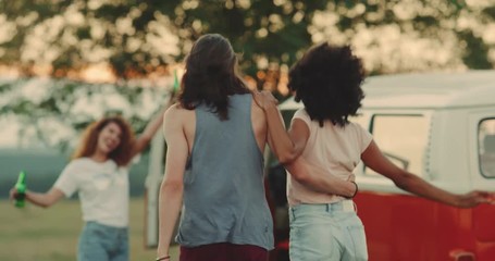 Two couples have a great time at the picnic they have a retro van beside. slow motions