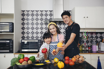 Happy Family have Dad, Mom and their little daughter Cooking Together in the Kitchen