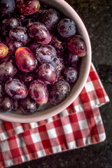 Red grapes in a bowl over a checkered napkin