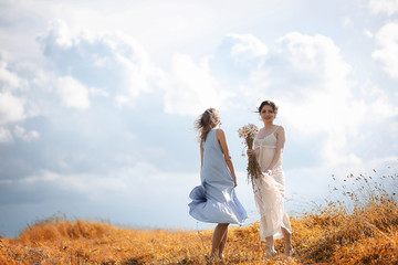 Two girls in dresses in autumn field