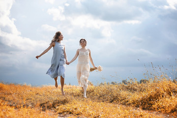 Two girls in dresses in autumn field