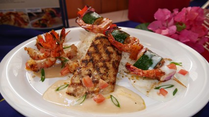 grilled fish with golden fried shrimp on skewers served with sauce and white rice.