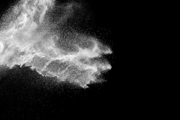 Bizarre forms of white powder explosion cloud against black background.White dust particles splash.