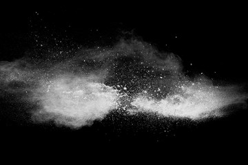 Fototapeta na wymiar Bizarre forms of white powder explosion cloud against black background.White dust particles splash.