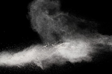 Bizarre forms of white powder explosion cloud against black background.White dust particles splash.