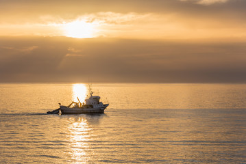 Fishing boat at sunset on the Coast of the Mediterranean at San Marco di Castellabate Italy