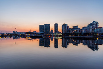 Fototapeta na wymiar Apartment Buildings and Reflections at Docklands London at Sunset