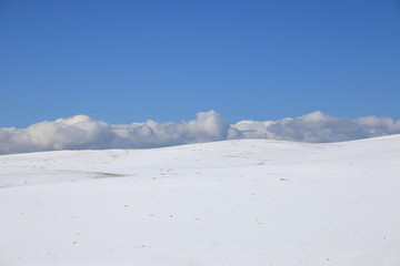 Fototapeta premium winter landscape. Snow slope, horizon, clouds