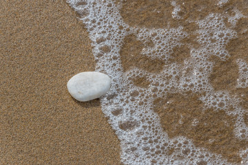 Single White Rock in the surf on the beach
