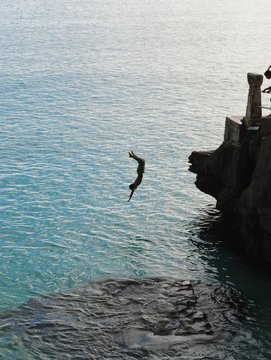 A boy somersaults off the edge of the Taga Beach cliff on Tinian, Northern Mariana Islands in February 2015. 