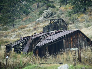 Dilapidated log cabin by the roadside at the Golden Gate mountains in Colorado 