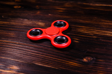 Red fidget spinner on wooden desk