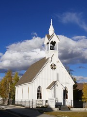 Wide portrait shot of a community Presbyterian church in Fairplay, Colorado, with beautiful clouds in the skies in the background