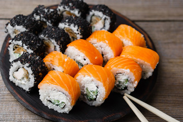 Food art, traditional seafood, restaurant menu photo. Tasty set of japanese sushi maki rolls served on round plate, selective focus.