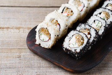 Tasty appetizing uramaki sushi rolls with crab meat, covered with sesame seeds, close up. Restaurant menu