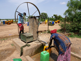 donna africana raccoglie l'acqua al pozzo 
