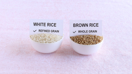 Refined grain white rice, and whole grain brown rice that is a healthy food, in bowls with a paper...