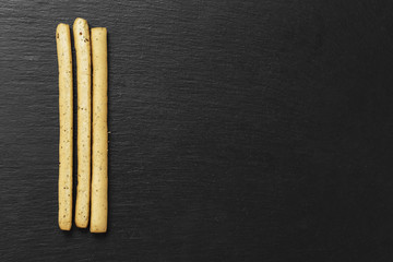 grissini breadsticks on a black background