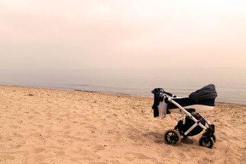 dziecięcy wózek stojący na plaży - obrazy, fototapety, plakaty