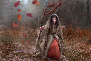 a witch in rags conjures in forest