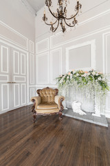 beige armchair. Spring style decoration. the white fireplace. Interior of bright room in classic royal luxury style