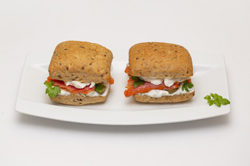 Sandwich with salmon, cheese and cereal bread on white background. Close up.