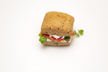 Sandwich with salmon, cheese and cereal bread on white background. Close up.