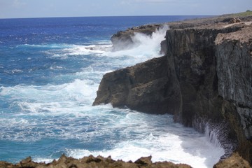 Dangerous steep cliffs with foaming waves at the As Matmos Fishing Cliff on Rota, Northern Mariana Islands