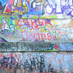Fragment of graffiti tags. The old wall is spoiled with paint stains in the style of street art culture