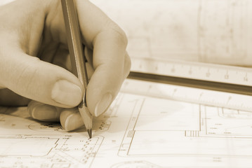 Woman's palm holding pencil and architectural plans