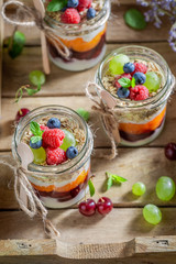 Delicious granola in jar with yoghurt and berry fruits