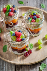 Healthy granola in jar with yoghurt and berry fruits
